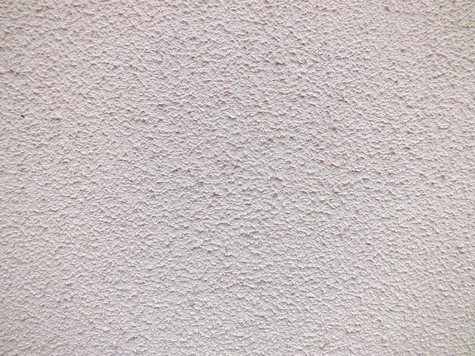 Mason applying cement plaster to a wall on a construction site